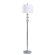 Standing lamp with white fabric drum shade and slim chrome pedestal base.