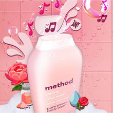 Pink body wash bottle close-up with floral graphics and water droplets