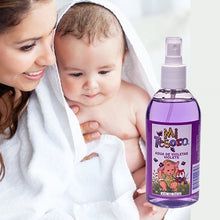 Purple violet cologne spray bottle with white spray nozzle, held near baby