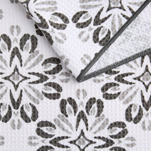 Floral print microfiber kitchen towel in white with dark leaves, gray stitched border.