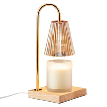 Electric candle warmer lamp with ribbed glass shade, brass arch stand, and lit white candle