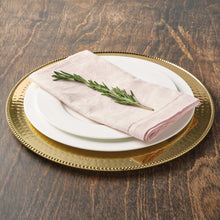 Gold stainless steel charger plate with textured rim and nested white plate