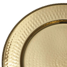 Close-up of gold stainless steel charger plate with hammered texture and inner rim