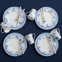 Four place settings with blue-and-white plates, bowls, and mugs
