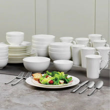 Bone china dinnerware set of white bowls, mugs, and plates arranged for serving