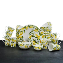 Lemon-and-leaf white dinnerware set with plates, bowls, and mugs in yellow and green