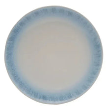 Blue and white ceramic dinner plate with speckled glaze rim