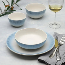 Blue and white dinnerware bowls and plates with speckled glaze pattern