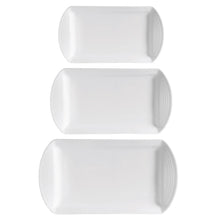 Three white oval serving platters with ribbed raised rims
