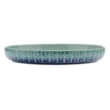Shallow stoneware bowl with teal glaze and blue geometric pattern along the rim