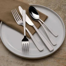 Satin-finish flatware set on plate: forks, spoon, and knife in polished silver