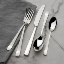Satin-finish flatware set on marble with napkin: forks, knife, and spoons in silver