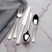 Stainless steel flatware set laid out with forks, spoons, and knife