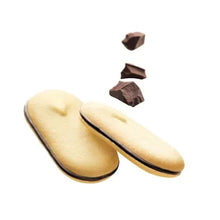 Two oval cookies with dark chocolate edges and a few chocolate pieces