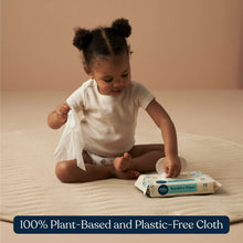 Baby sensitive wipes pack on mat as child reaches for a wipe packet