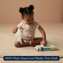 Sensitive wipes pack on a blanket near a kneeling toddler