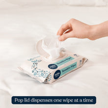 Hand pulling a wipe from a pop-top sensitive wipes pack