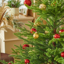 Red and gold hanging Christmas ornaments on green tree branches