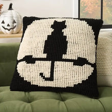 Black-and-white knitted Halloween pillow with central black figure