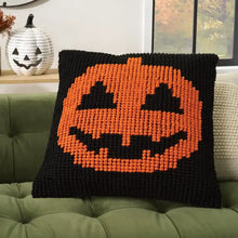 Orange jack-o’lantern face knitted pillow with black border