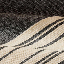 Woven outdoor rug close-up with black, ivory, and thin stripe lines