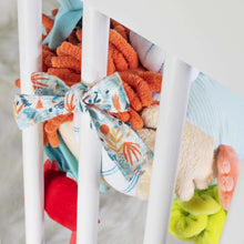 Hanging plush sensory reef toy attached to a baby activity frame