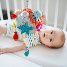 Plush sensory reef toy with octopus, starfish, and fluffy orange fringe details