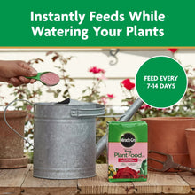 Miracle-Gro Rose Plant Food box beside watering can with green scoop for feeding