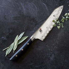 Miyabi Santoku knife with dark handle and light blade, scalloped edge and red logo