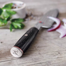 Santoku knife handle with black wood grip, metal bolster, and red ring detail