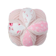 Pink plush sensory ball with bow-knot center and mixed rose and polka-dot patches