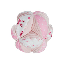 Pink plush sensory ball with rose print and ribbon loops, crinkly textured panels