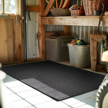 Black rubber all-purpose mat on the floor in a storage/work room