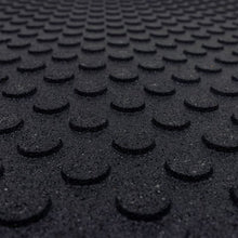 Extreme close-up of black rubber mat surface with circular raised bumps