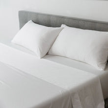 White sheet set on a bed with matching pillowcases and smooth fabric