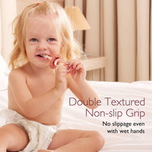 Toddler holding a brown silicone toothbrush with textured non-slip grip