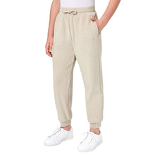 Beige youth jogger pants with drawstring waist and cuffed hems; white sneakers.