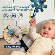 Blue pull-string sensory toy with carry strap, held by baby on sofa.