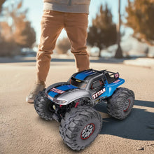 2WD RC truck car with silver-and-blue body and large black off-road tires on pavement
