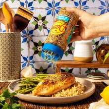 Garlic & herb seasoning bottle being poured over chicken and green beans