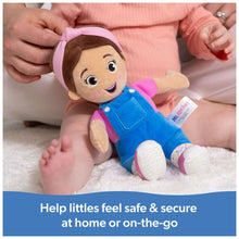Ms. Rachel plush doll in blue overalls with pink hood, lying on a soft blanket