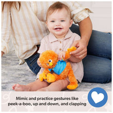 Orange plush bird with blue shirt and yellow beak, cuddled by a child on the floor
