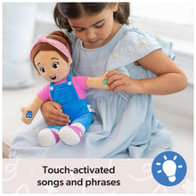 Close-up of a child holding plush doll with pink headband and blue overalls
