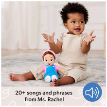 Baby playing with 16-inch plush doll wearing pink shirt, blue overalls, and pink headband