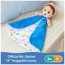 Plush lovey doll with blue two-sided blanket and colorful musical print on couch
