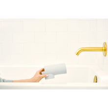 Gray silicone spout guard held in hand for attaching to a faucet
