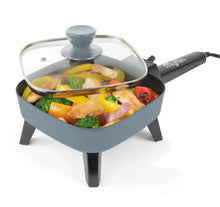 Gray electric skillet with clear tempered glass lid and black power handle, filled with food