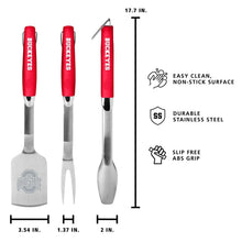 Three stainless grill tools with red handles, including spatula and fork