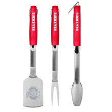 Three-piece stainless grill tool set with red handles: spatula, fork, and spoon