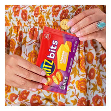 Snack cookie bag held in hands, red packaging with cookie graphics and printed flavor name